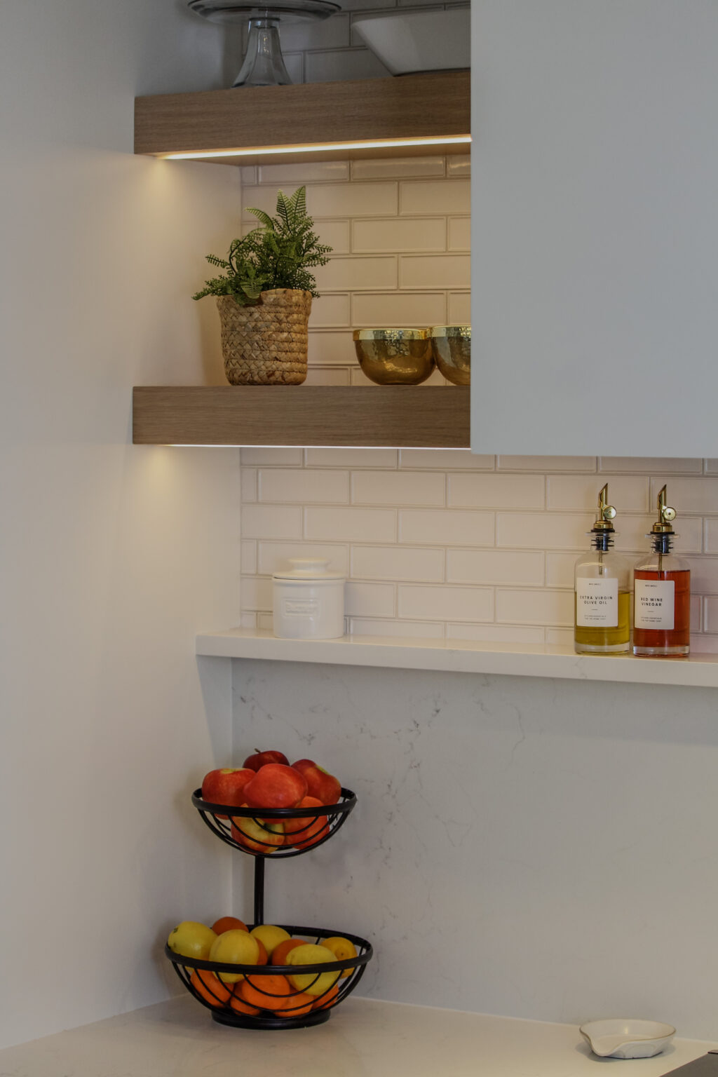 Corner of kitchen featuring floating shelves with LED downlighting. Shelves are made of rift cut white oak, with a natural light wash finish