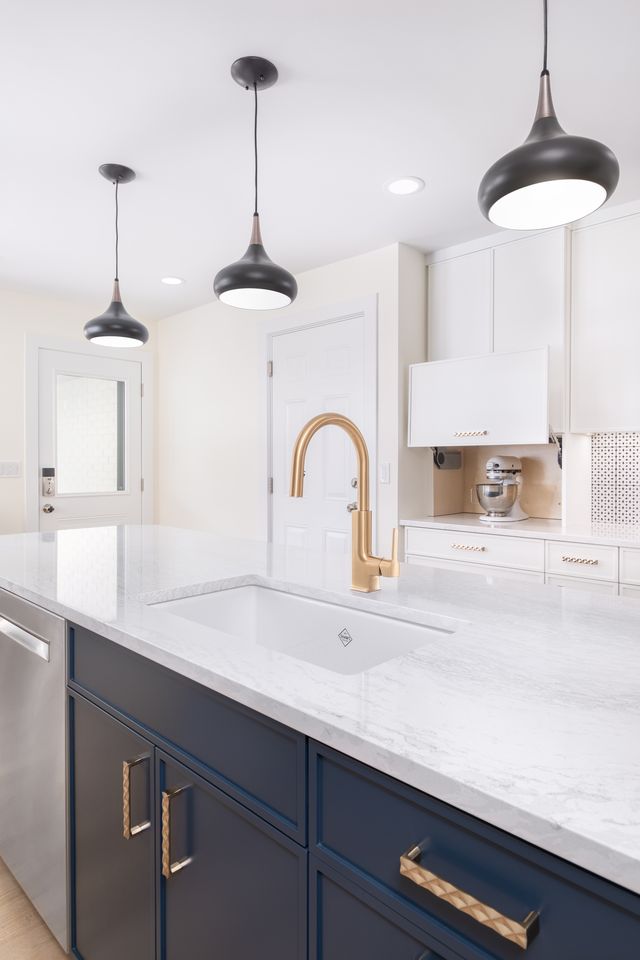 Kitchen cabinetry and island made of maple featuring Cologne door frames. Kitchen cabinetry painted in the white finish and kitchen island painted in the naval finish