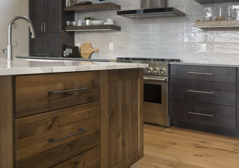 Kitchen cabinetry and island made of knotty alder wood with the Mission door style. Cabinetry is stained the shade iron and island is stained with the shade caramel. Image focus is the kitchen island.