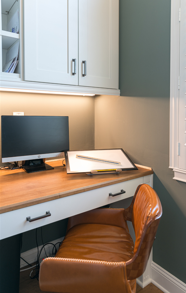 Office cabinetry made of maple wood with a snow painted finish in the mission door style with matching desk