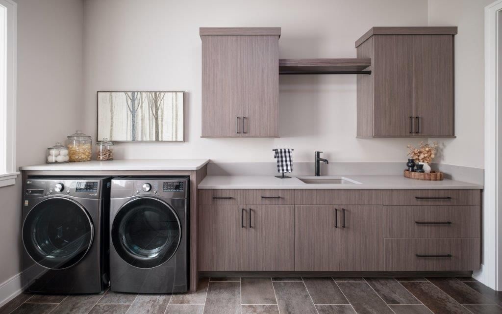 Laundry room cabinetry made of textured melamine finished in the shade linea vail and featuring linea V doors