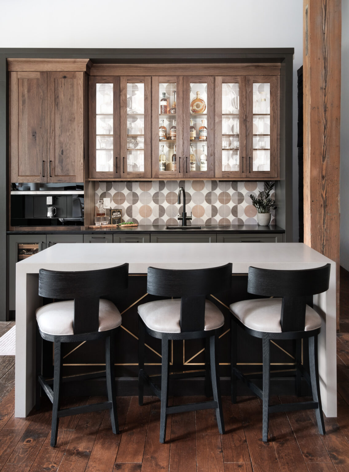 Beverage bar featuring hickory upper cabinetry and painted maple lower cabinetry. Image is focused on the island seating in front of the beverage bar.